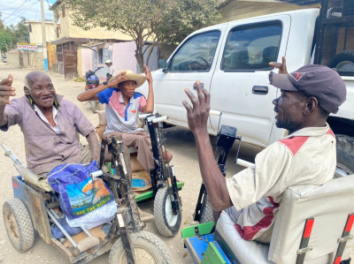 PET Cart recipients raise their hands in gratitude to God for receiving food and mobility.