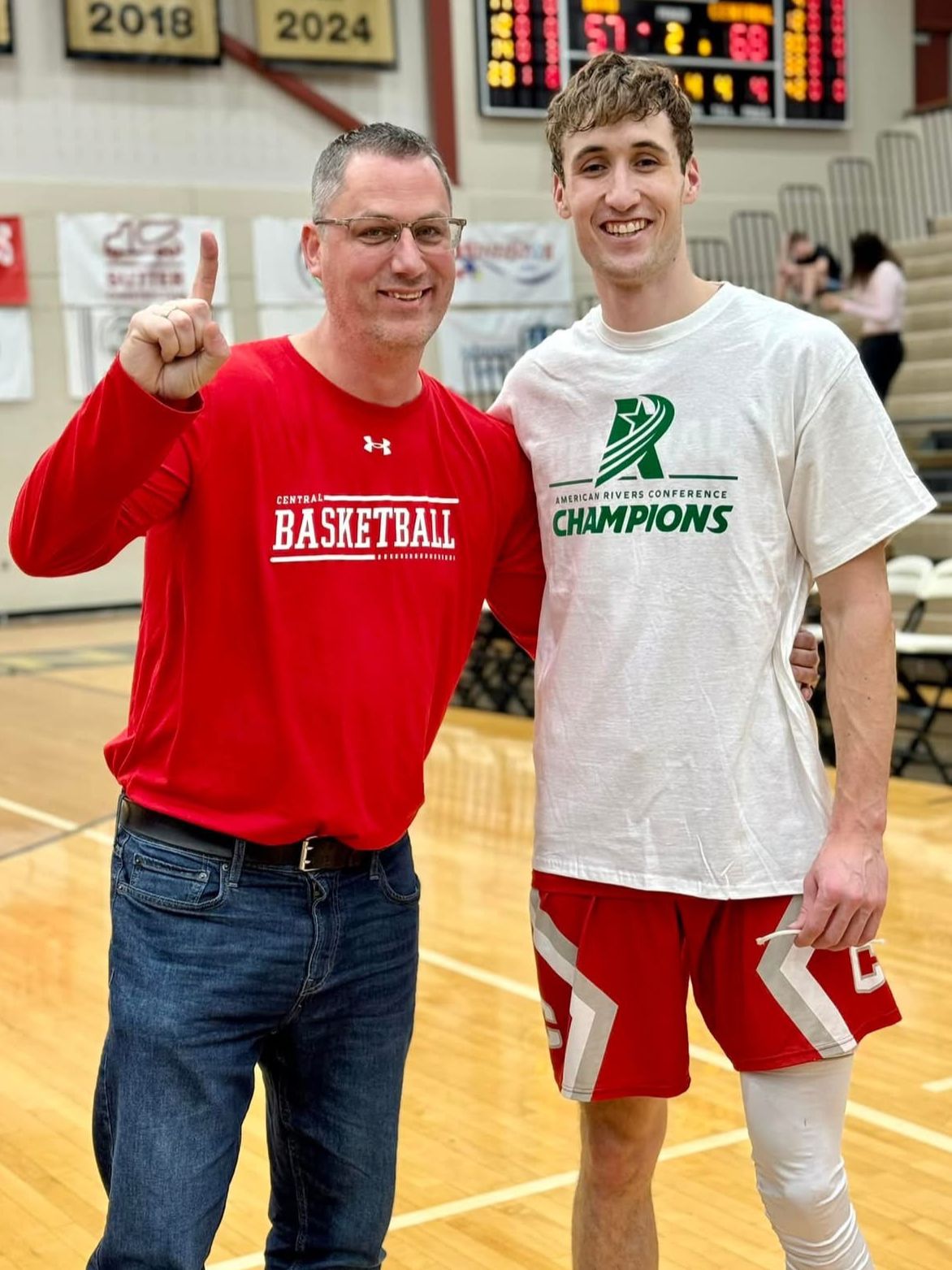 Tim Brand smiling with his nephew Kaleb after a basketball championship