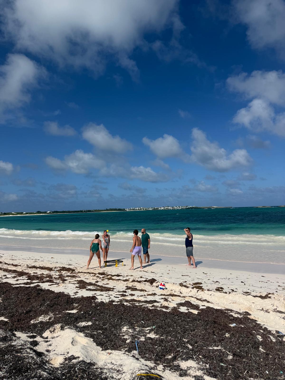 Lutheran Church of Hope Ames volunteers play spikeball on a white sand beach in Abaco, building team fellowship and resting during their Many Hands IMPACT trip.