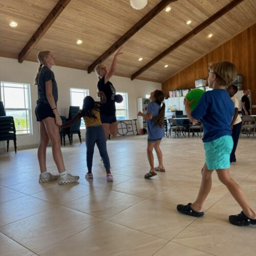 Impact team volunteers host a faith-based kids' club session at Kirk of the Pines, engaging local children in active games centered on lessons about the fruit of the Spirit.