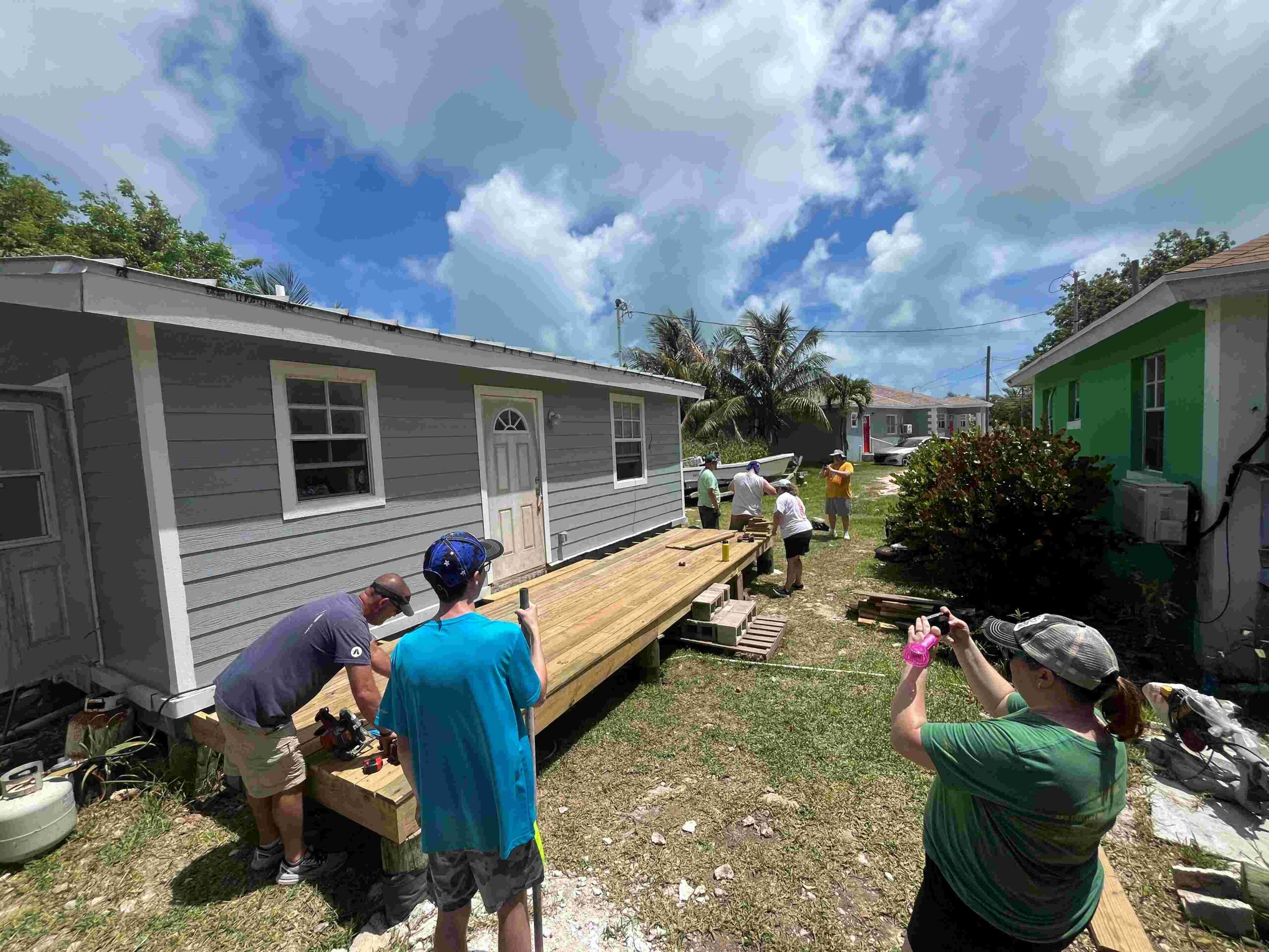 Celebrate Church team members work on completing a wooden deck for a front porch on one of Many Hands' Safe Homes projects.