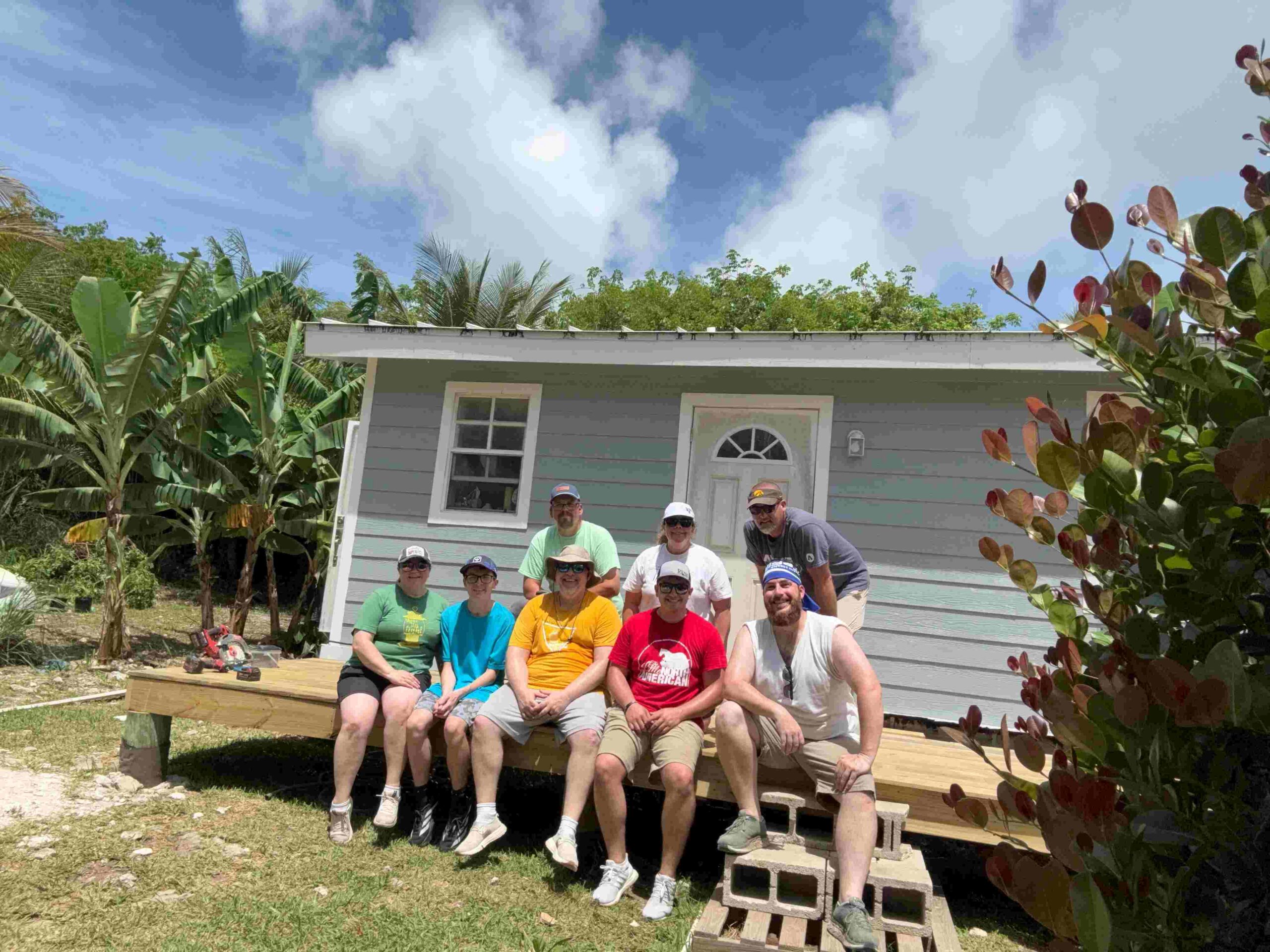 Celebrate Church Impact team members smile on a newly finished front porch that they finished for a homeowner in Abaco.