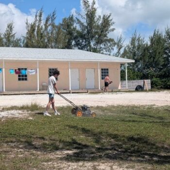 DMC impact team volunteers perform lawn maintenance and beach cleanup at Camp Abaco, supporting the behind-the-scenes physical infrastructure that makes Many Hands trips possible.