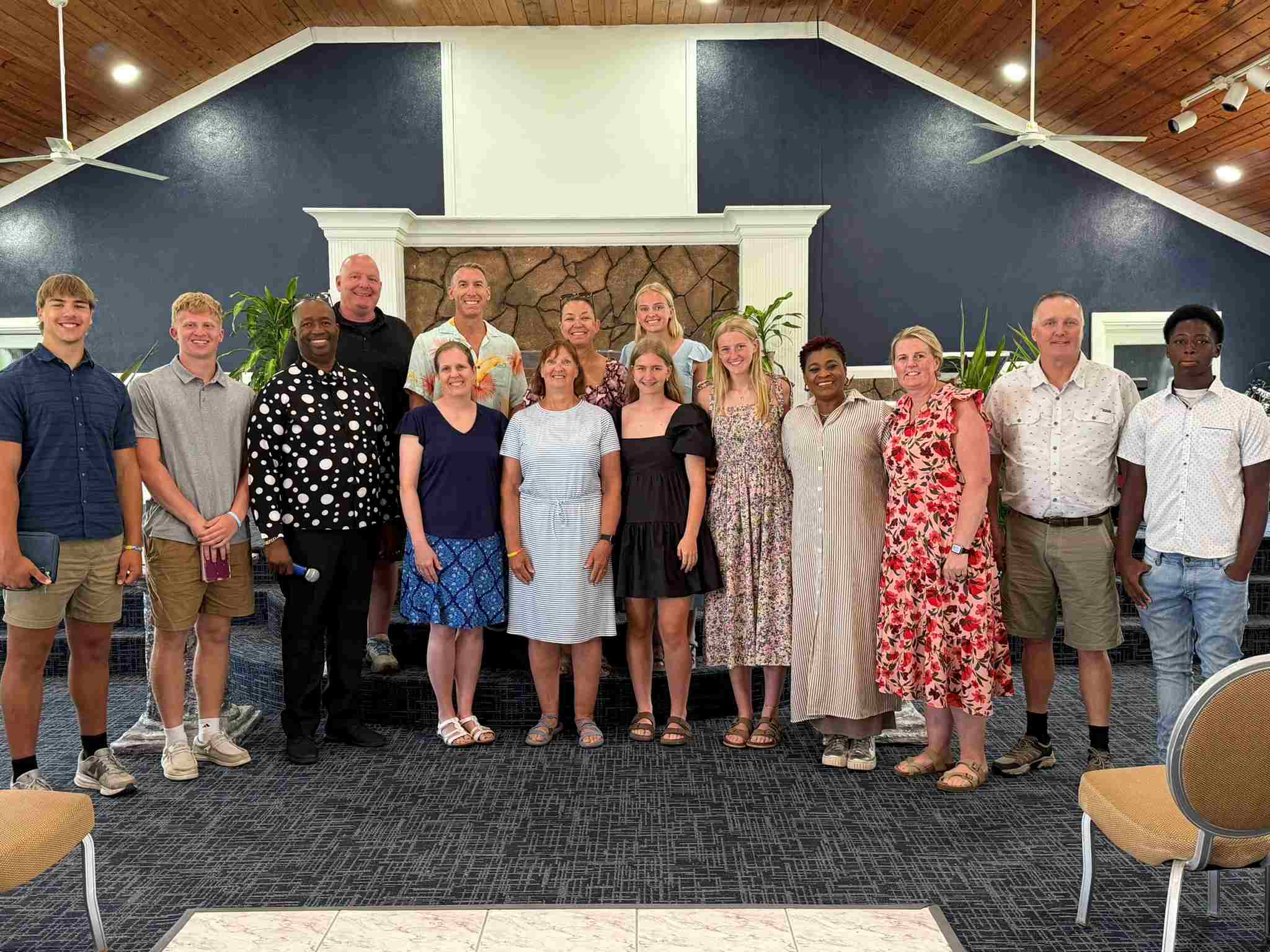 The Immanuel CRC Youth Impact Team poses on stage with local congregation leaders at Grace Baptist Church in Abaco, celebrating a Sunday of shared worship and community connection.