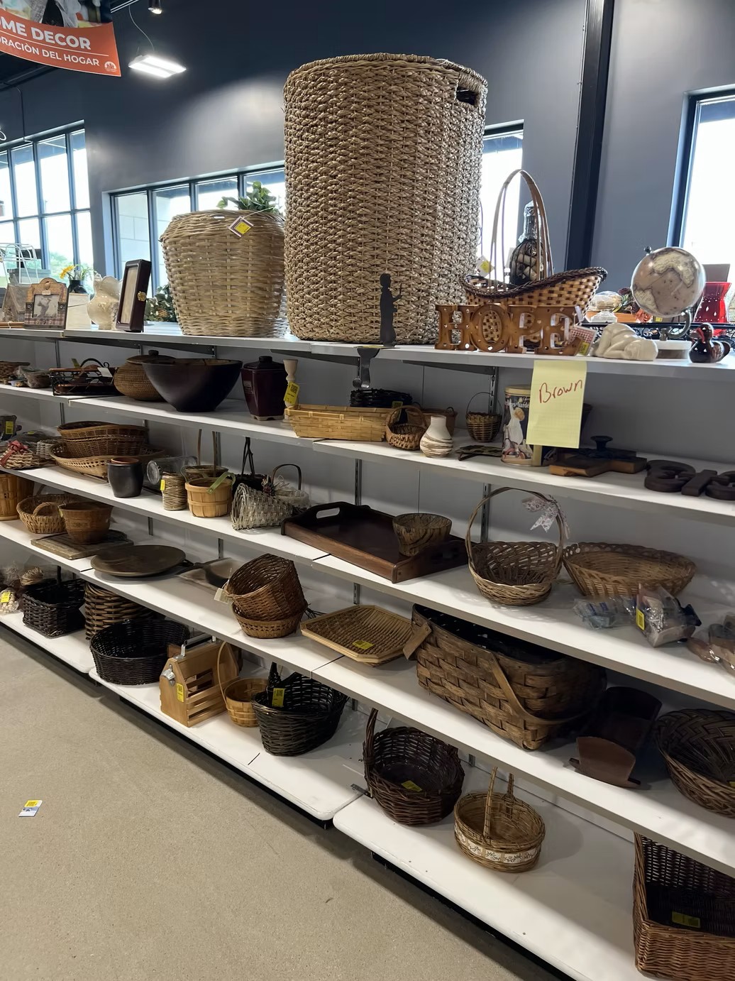 Shelves organized with woven baskets and decorative home items at the new Jordan Creek Thrift Store.