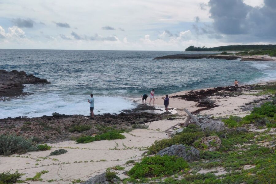 Impact team members gather along the rocky shoreline and sandy beach in Abaco, experiencing rest and reflection in God's creation.