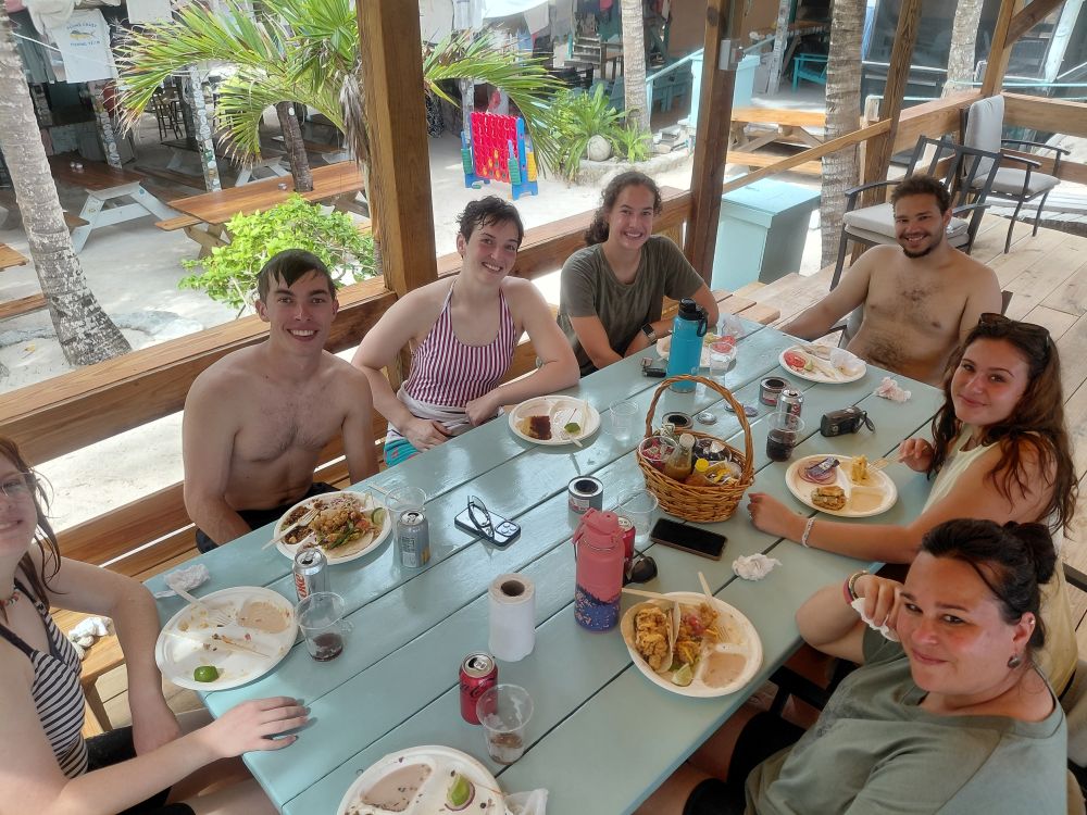 Short-term volunteers enjoy a meal together at an open-air restaurant, experiencing local Bahamian culture during a scheduled rest day.