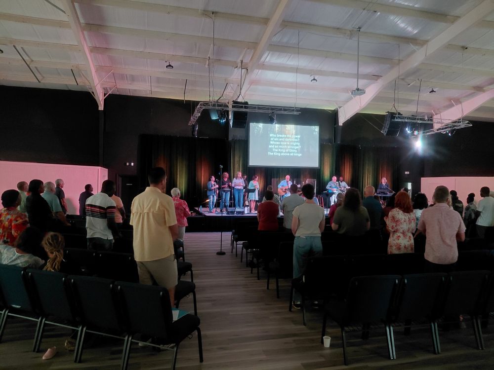 Many Hands impact team members join local Bahamian believers in standing worship during a Sunday church service in Abaco.